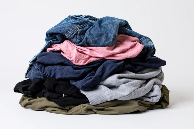 A messy pile of mixed clothing heaped on a flat surface