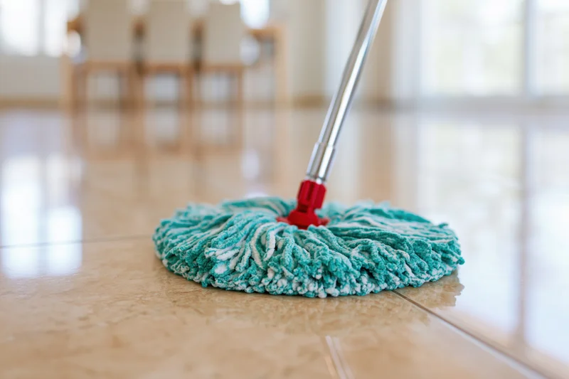 Microfiber mop head resting on polished tile floor in home interior