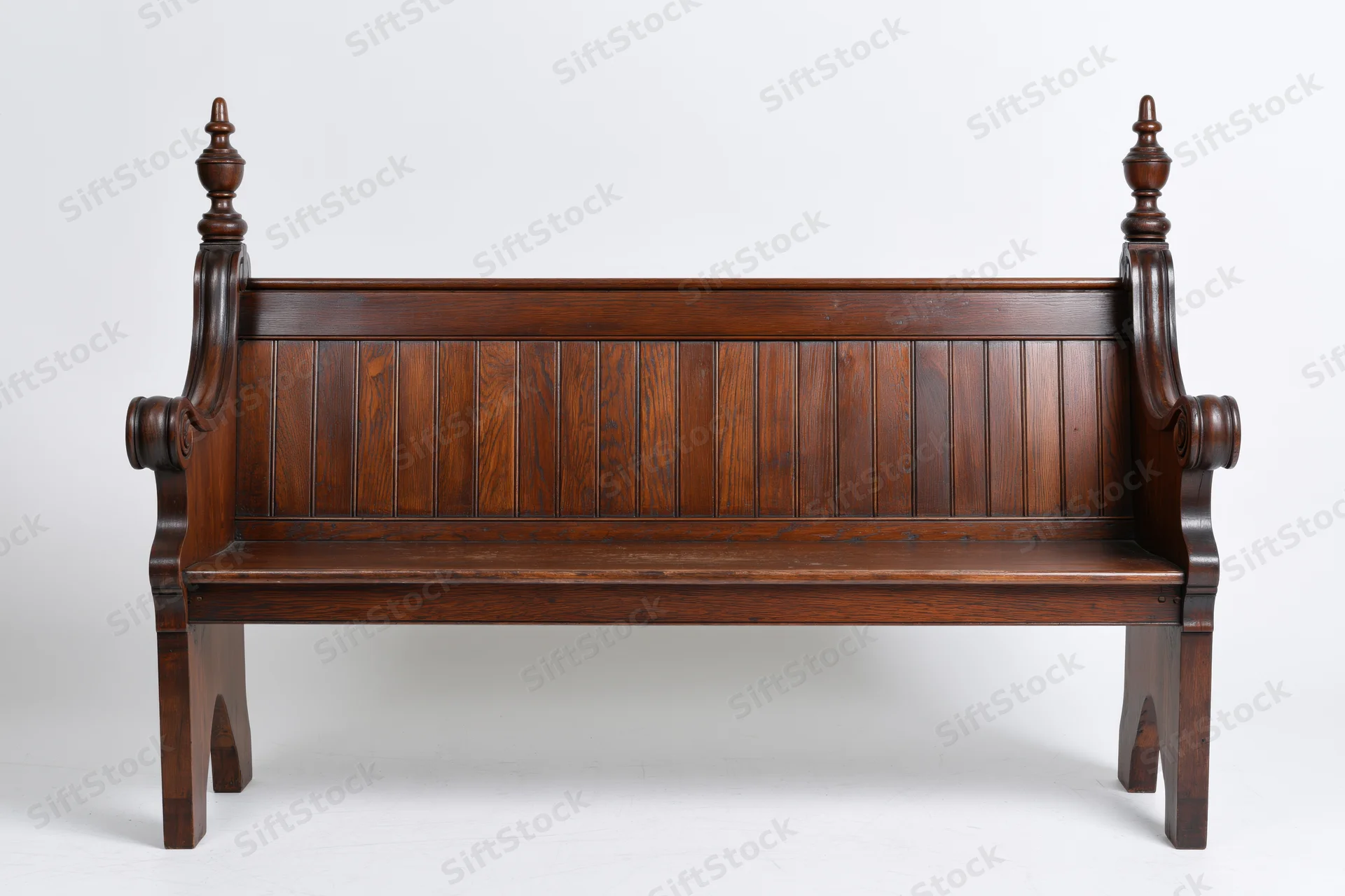 Antique wooden church pew with vertical plank backrest and carved finials on white background