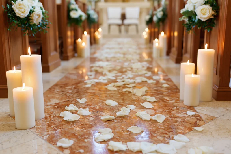 Wedding aisle decorated with white candles and rose petals in a church interior