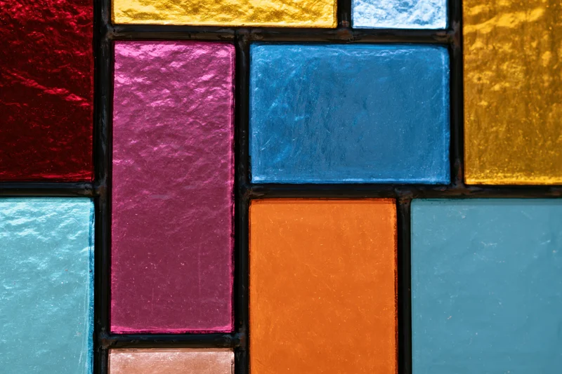 Close-up of a geometric stained glass window panel with colorful glass pieces arranged in a mosaic pattern