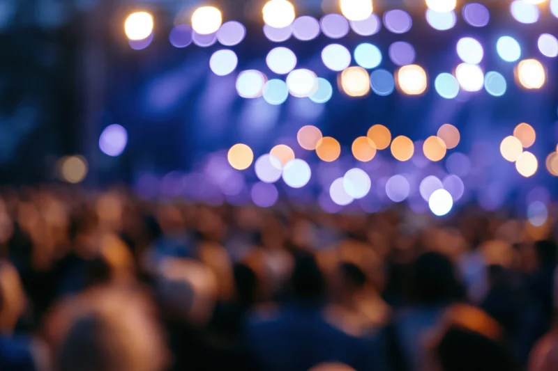 Defocused crowd silhouetted against stage lights at a live music concert