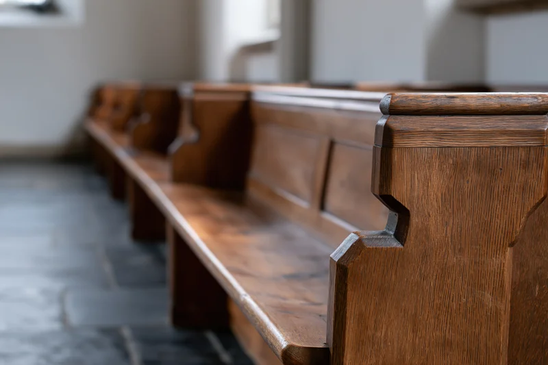 Wooden church pews in a row viewed from low angle inside a sanctuary