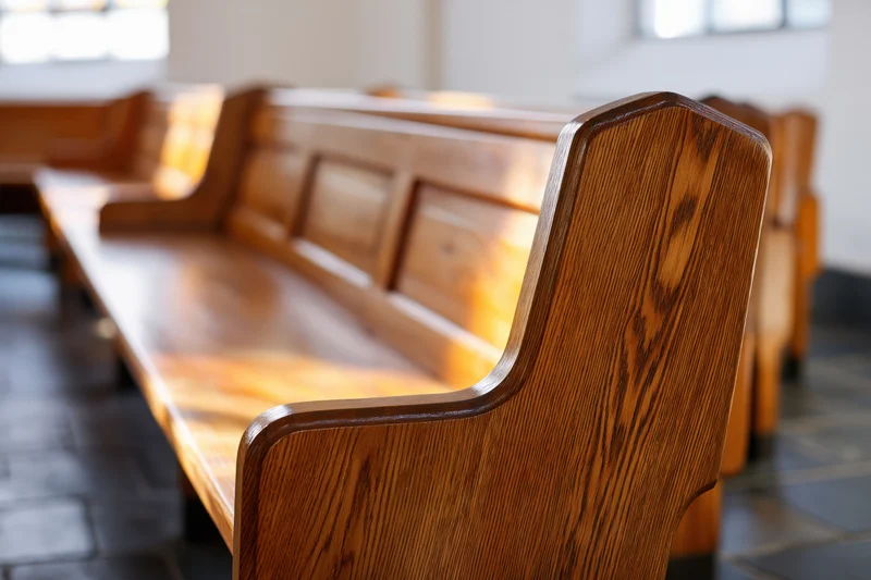 Wooden church pews in a row viewed from low angle inside a sanctuary