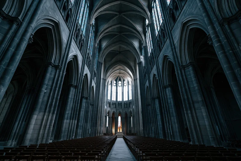 Gothic cathedral nave interior with stone arches and stained glass windows lining the central aisle