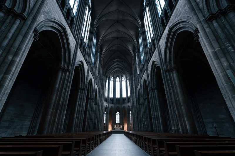 Gothic cathedral nave interior with stone arches and pews leading to altar under vaulted ceiling