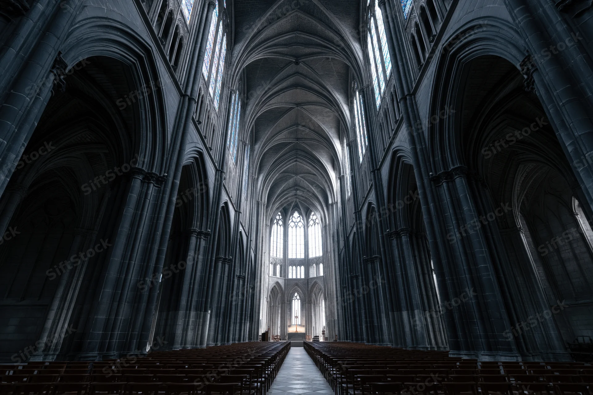 Gothic cathedral nave interior with stone arches and stained glass windows lining the central aisle