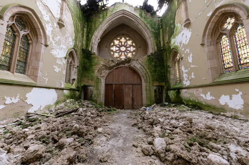 Interior of abandoned gothic church nave with collapsed ceiling and rubble covering floor
