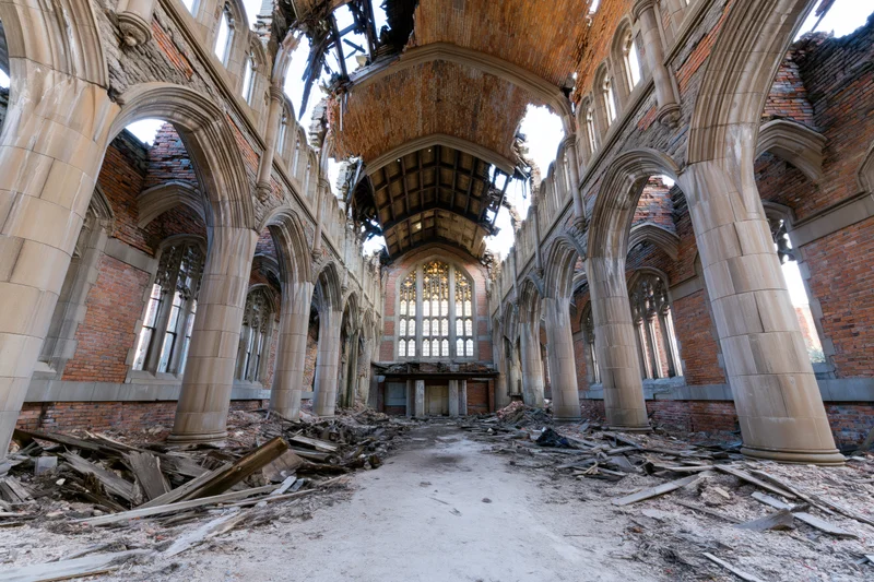 Interior of a ruined gothic stone church nave with collapsed ceiling and debris on floor