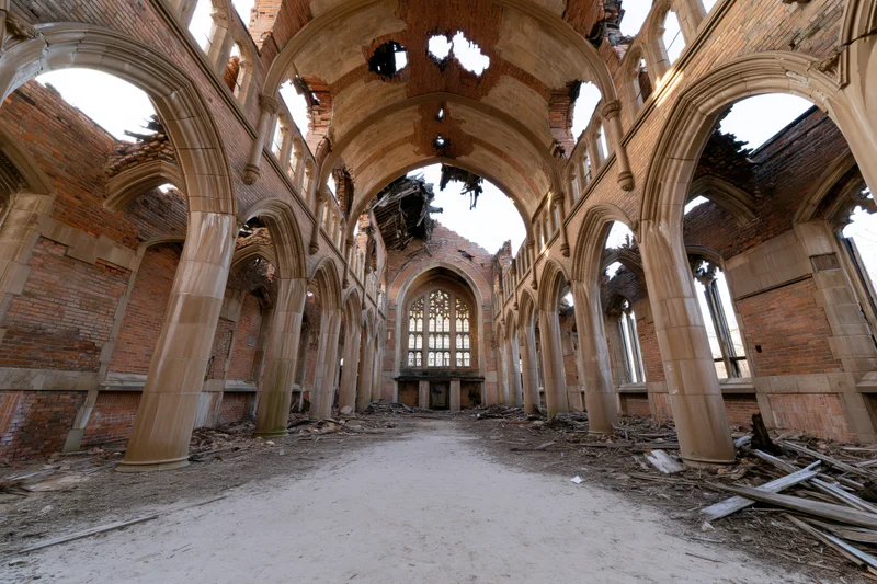 Interior of abandoned gothic church nave with broken ceiling and rubble on floor