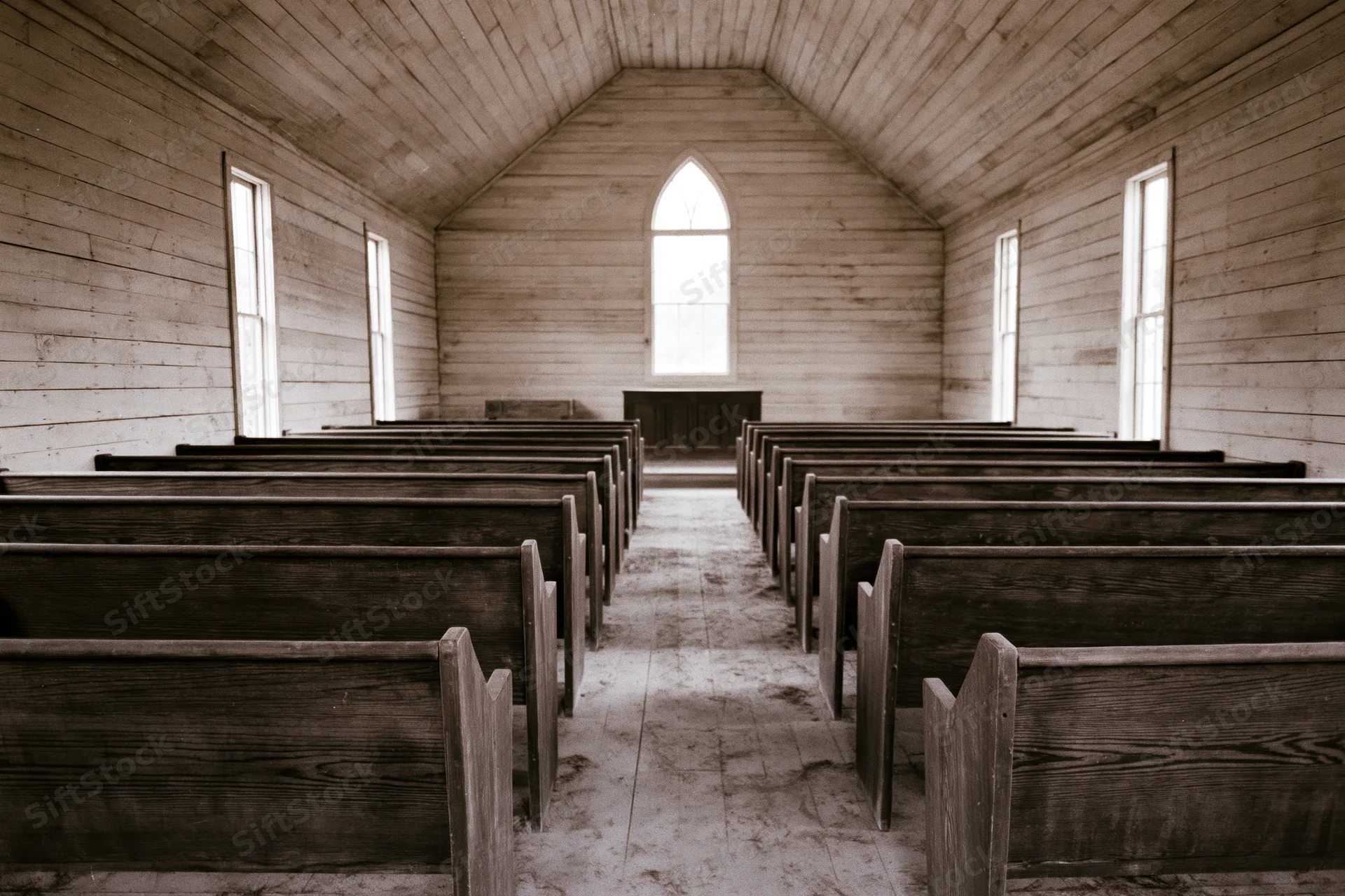 Rows of wooden pews in an abandoned rural church interior