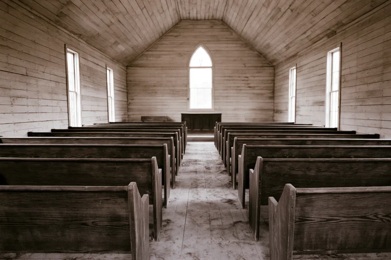 Rows of wooden pews in an abandoned rural church interior