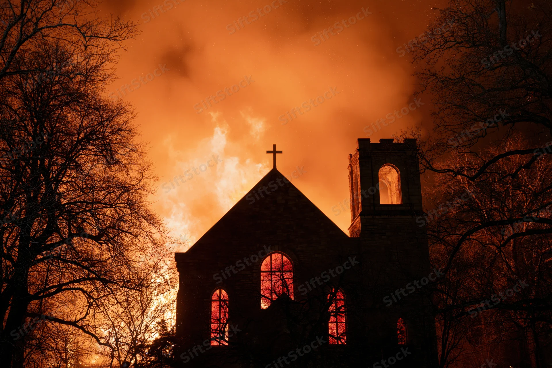 Stone gothic church engulfed in flames at night with cross and arched windows glowing through smoke and bare trees