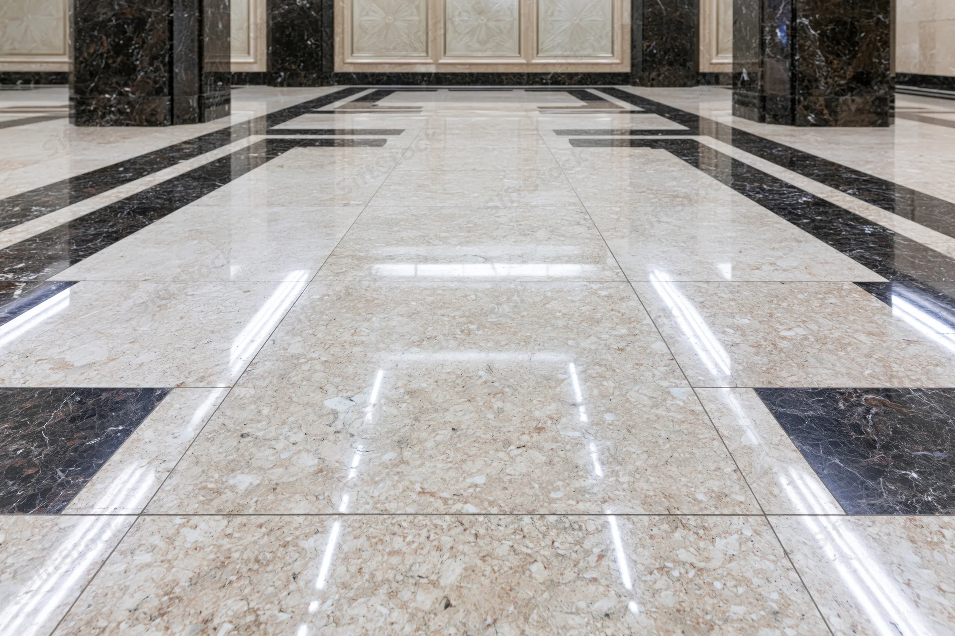 Polished marble floor in a formal building lobby with reflective tiles and symmetrical pattern