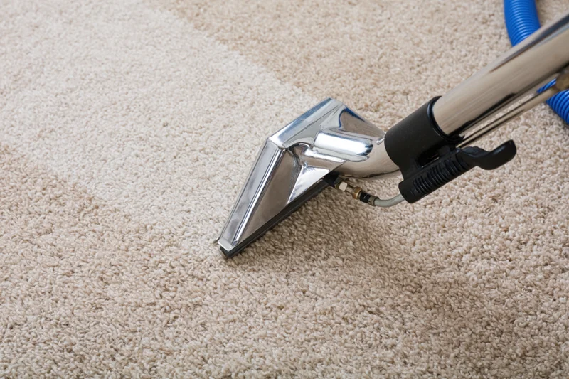 Carpet cleaning wand moving across beige carpet surface