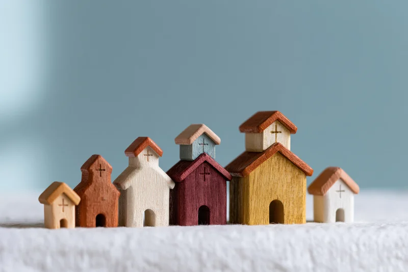 Small wooden church figurines arranged in a row on a white textured surface