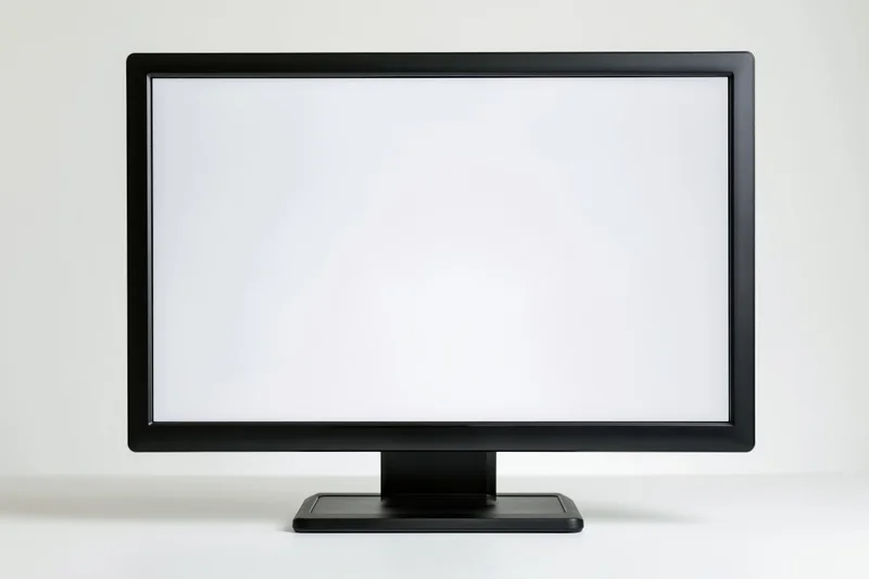 Black computer monitor with blank white screen on white surface