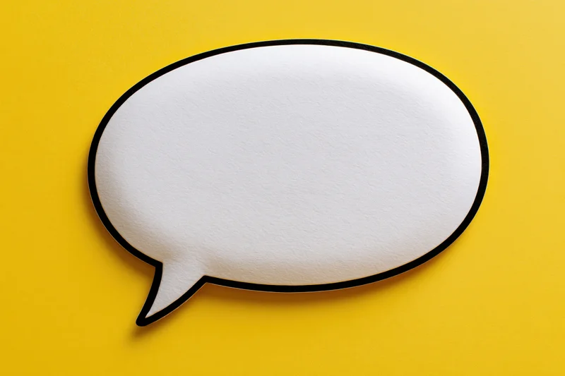 Blank white speech bubble with thick black outline on yellow background