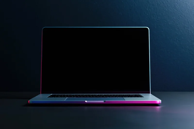 Silver laptop with blank screen and neon glow on dark surface
