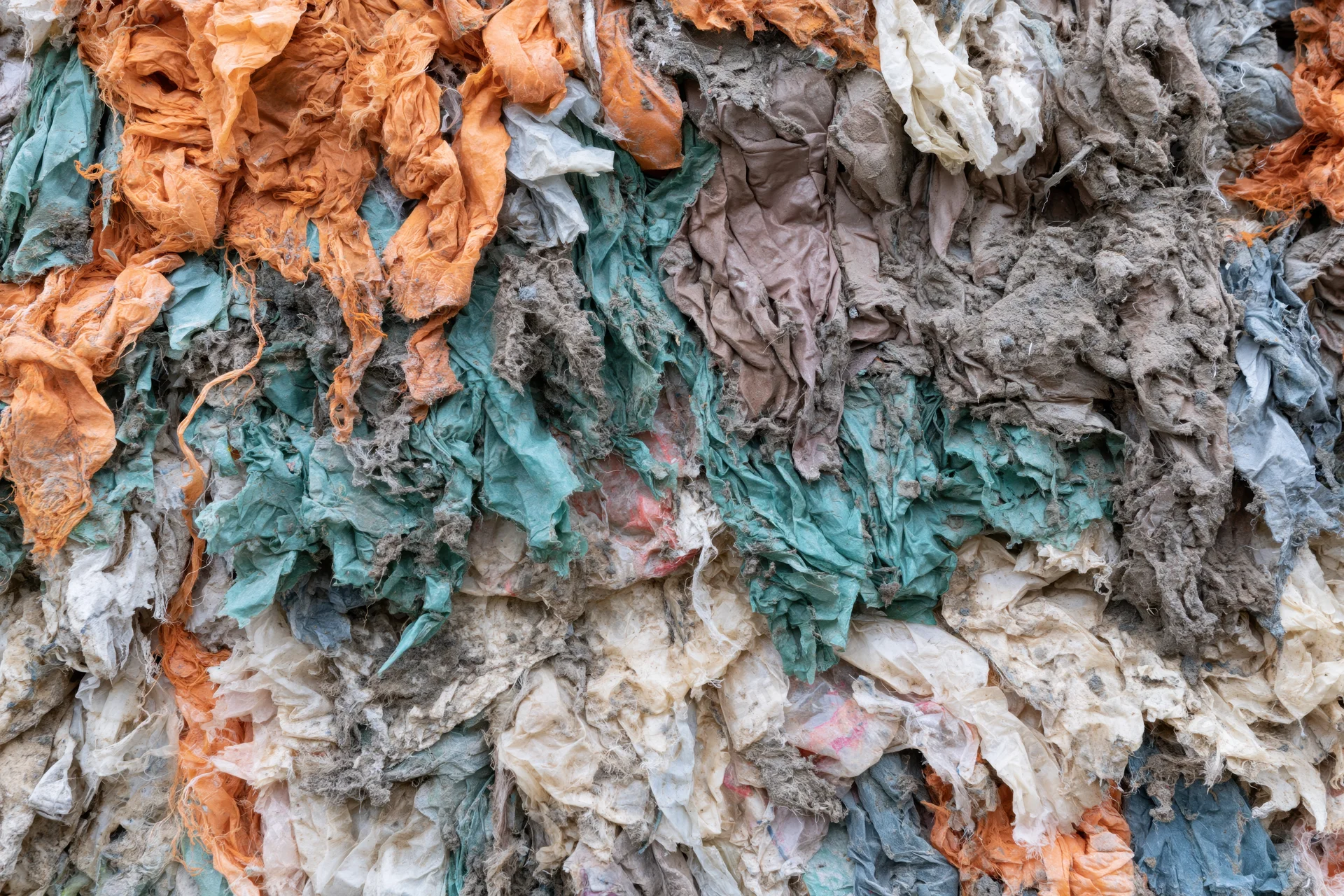 Compressed wall of shredded textile waste in industrial recycling facility