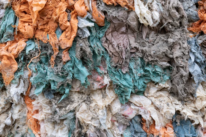 Compressed wall of shredded textile waste in industrial recycling facility