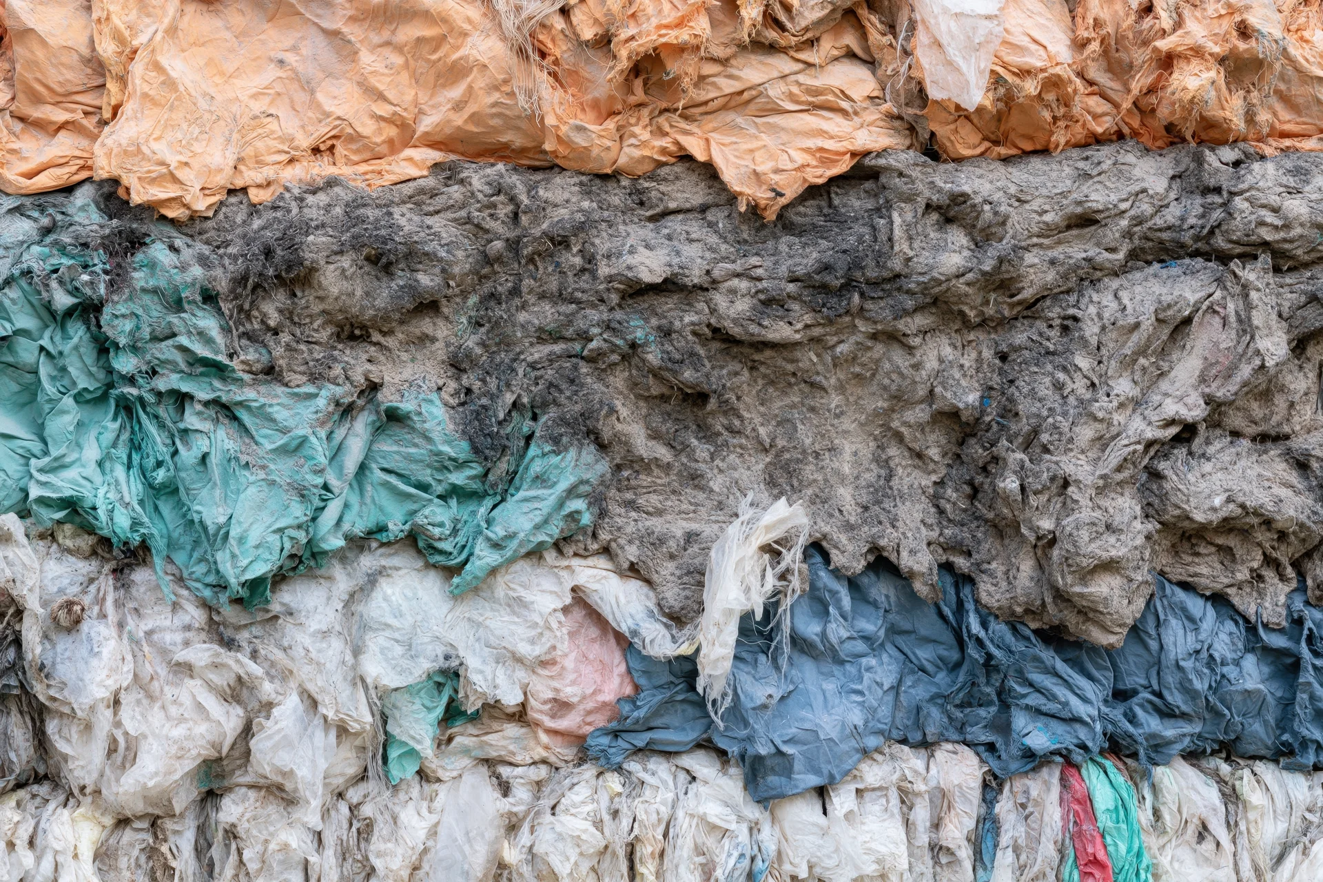 Compressed layers of discarded textiles stacked in a bale at a recycling facility