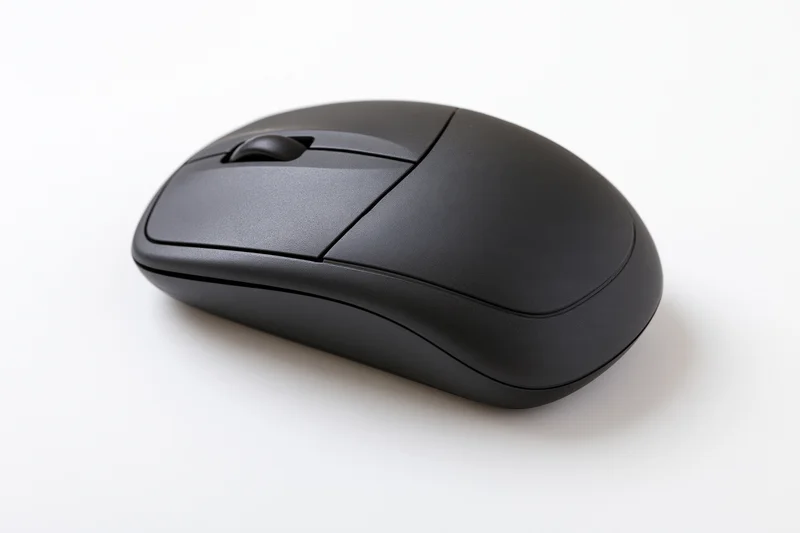 Matte black wireless computer mouse on plain white surface