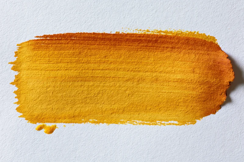 Horizontal watercolor brushstroke in yellow and orange gradient on textured white paper
