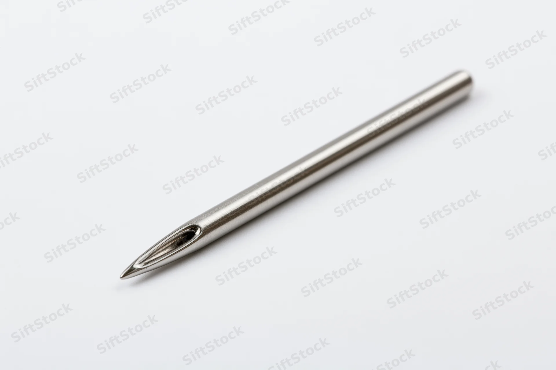 Steel sewing needle lying diagonally on white background