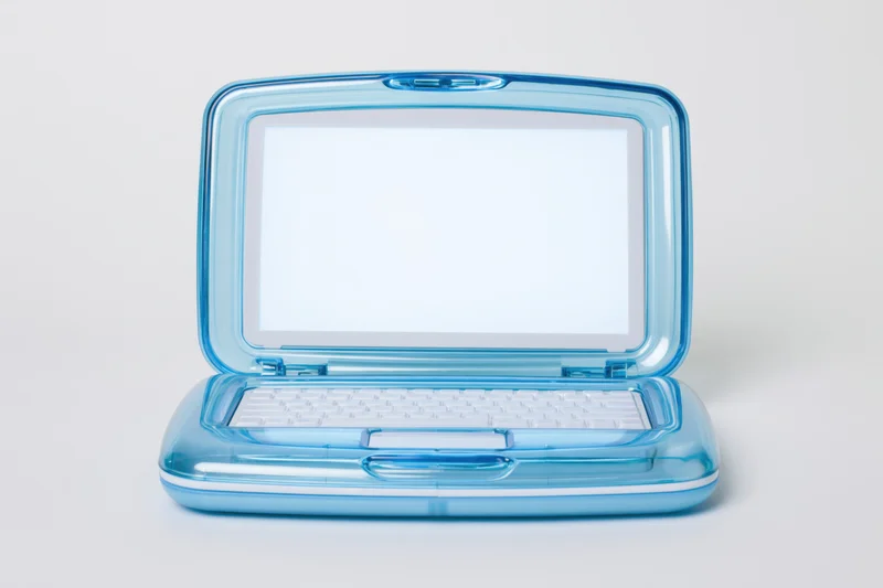 Translucent blue plastic childrens toy laptop open with blank screen and white keyboard on white background