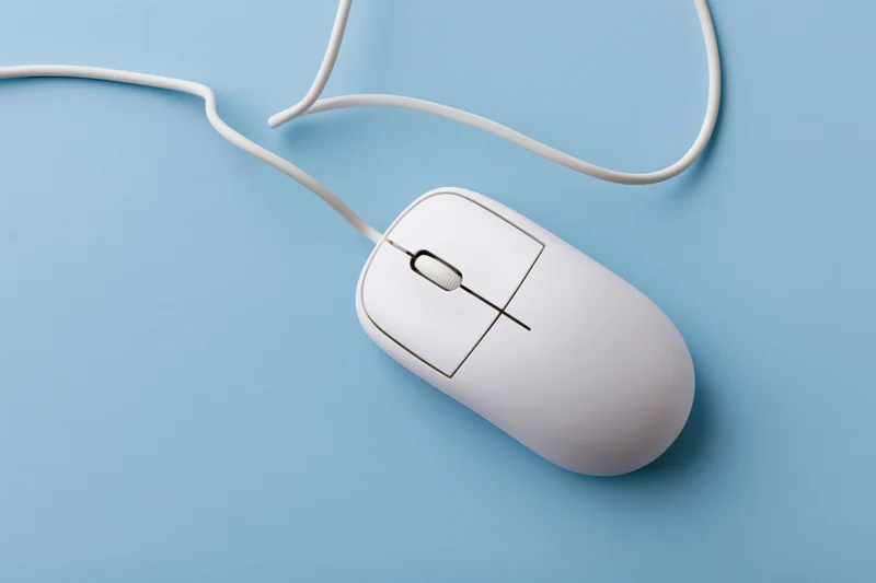 White wired computer mouse with scroll wheel on blue surface