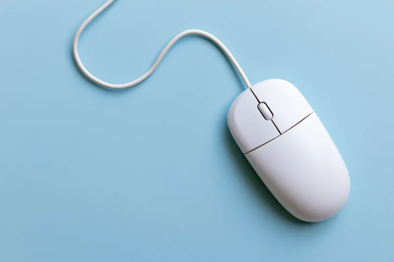 White wired computer mouse with scroll wheel on blue background
