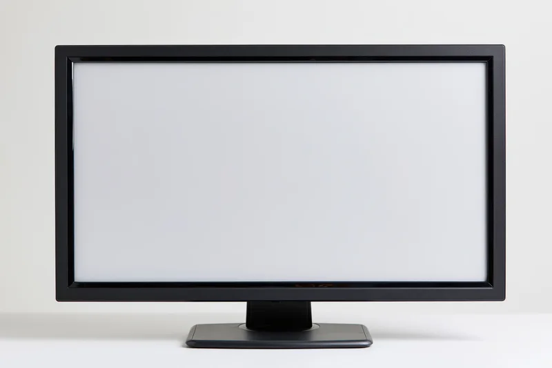 Widescreen desktop computer monitor with blank white screen on white surface