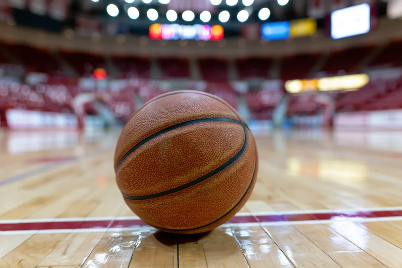 Basketball resting on painted court line in indoor arena