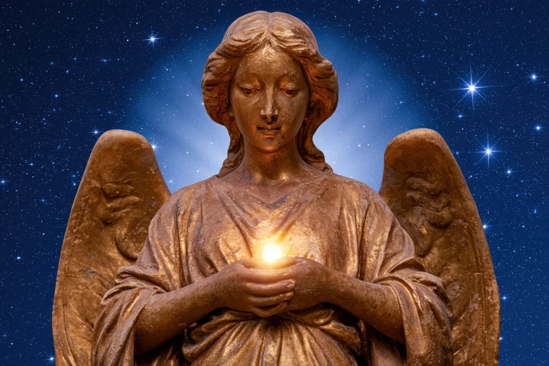 Golden angel statue holding glowing light against starry night sky