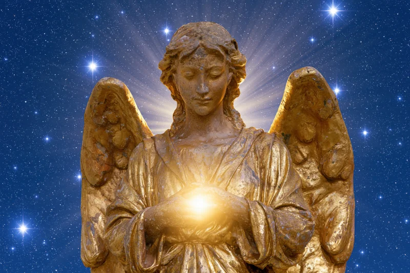 Golden stone angel statue with folded wings holding glowing light against starry night sky