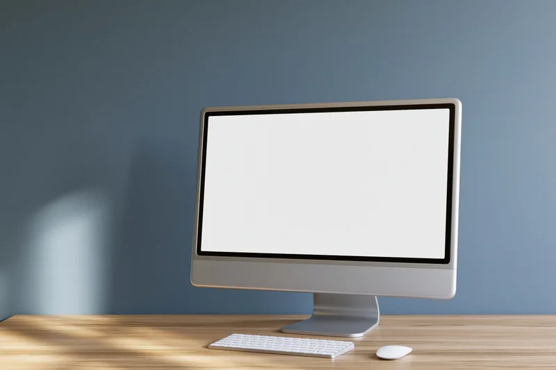 All-in-one desktop computer with blank white screen on wooden desk in office setting