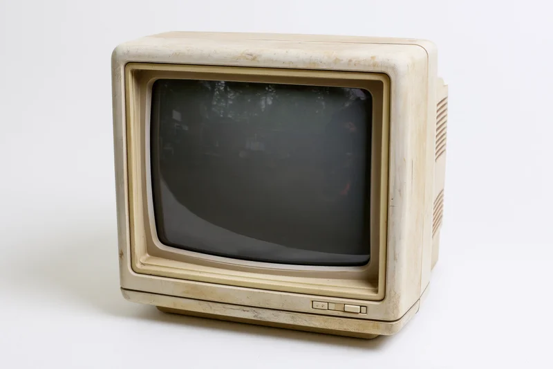 Vintage beige crt computer monitor with curved screen and plastic casing on white background