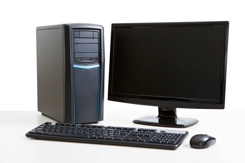Black desktop computer tower with blue accent stripe, monitor, keyboard and mouse on white surface