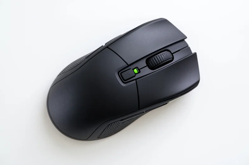 Black gaming computer mouse viewed from directly above on white surface
