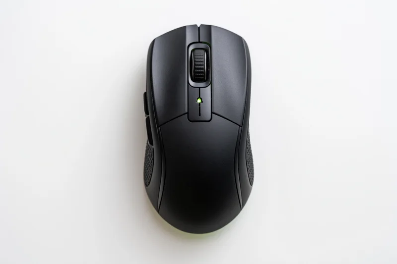 Black gaming computer mouse viewed from directly above on white surface