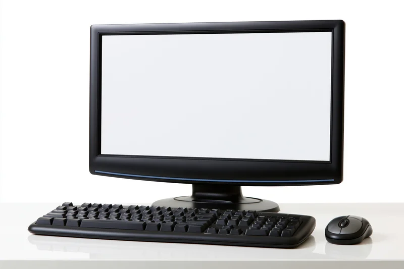 Black desktop computer monitor with blank white screen, keyboard and mouse on white desk