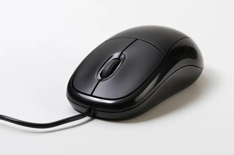 Black wired computer mouse with scroll wheel on white surface