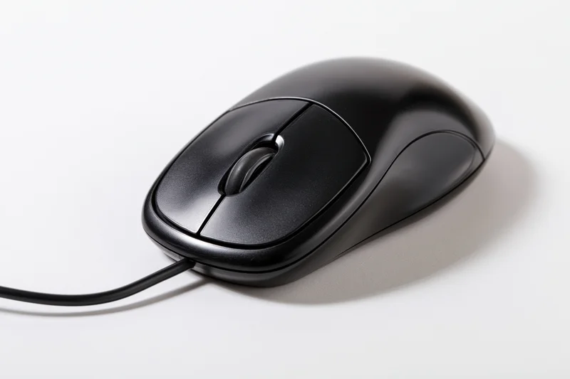 Black wired computer mouse with scroll wheel on white surface