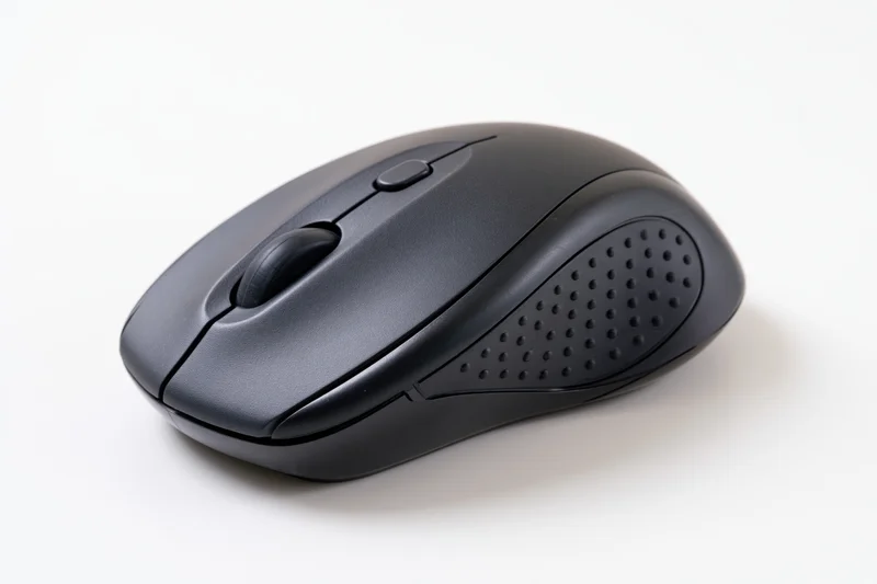 Black wireless computer mouse on plain white surface