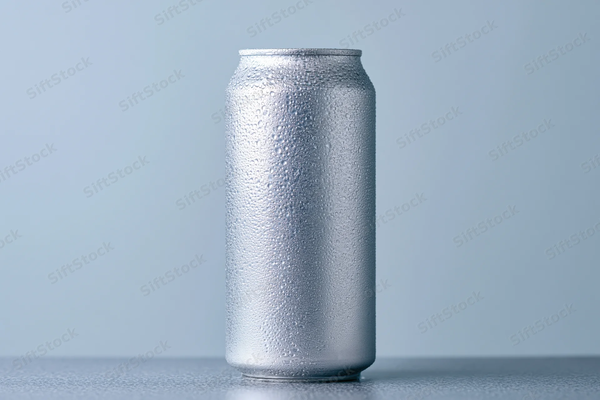 Aluminum beverage can covered in condensation droplets on a plain surface