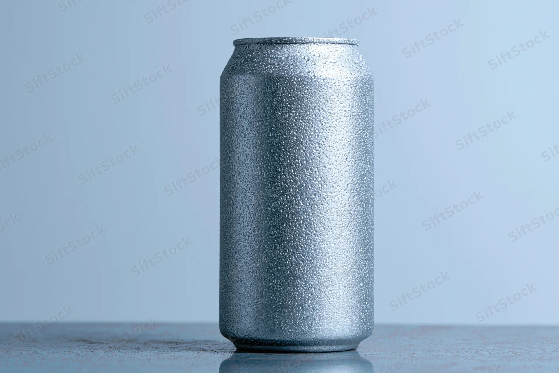 Aluminum beverage can covered in condensation droplets on a reflective surface
