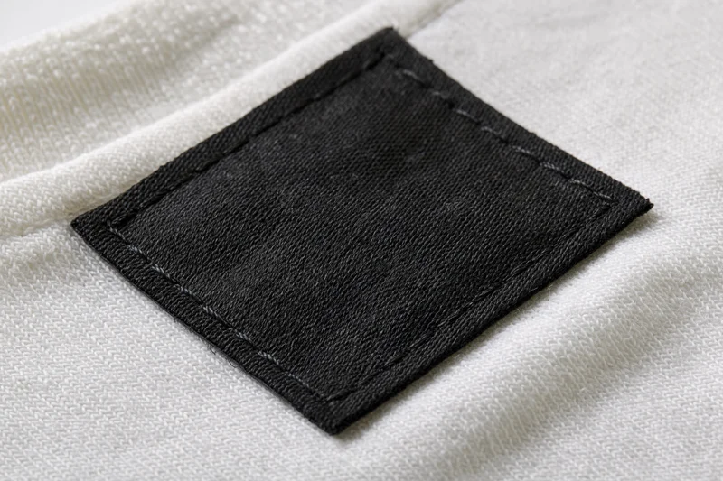 Blank black fabric label stitched onto white textile garment