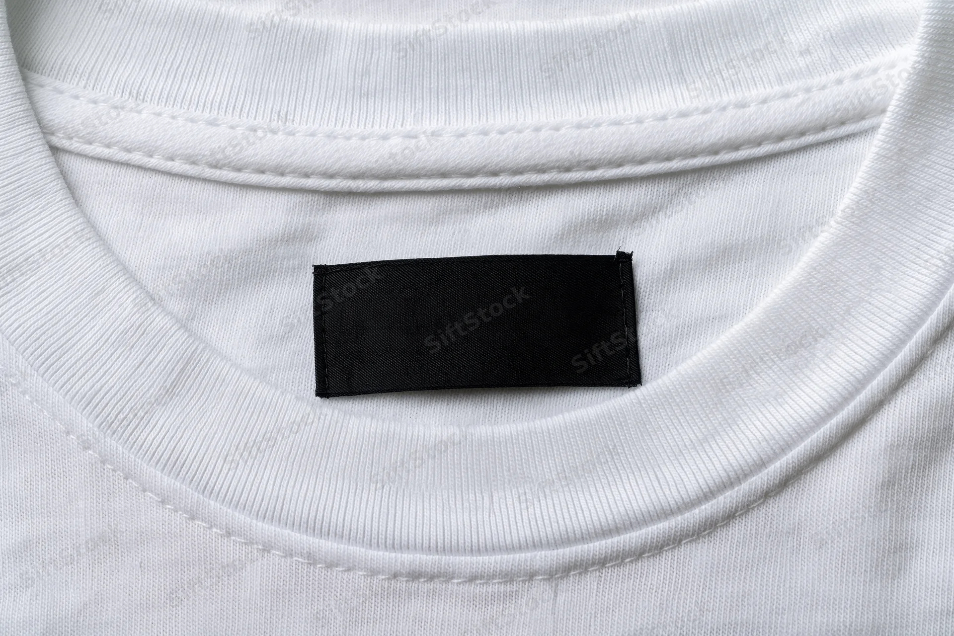Closeup of blank black label sewn inside white tshirt collar