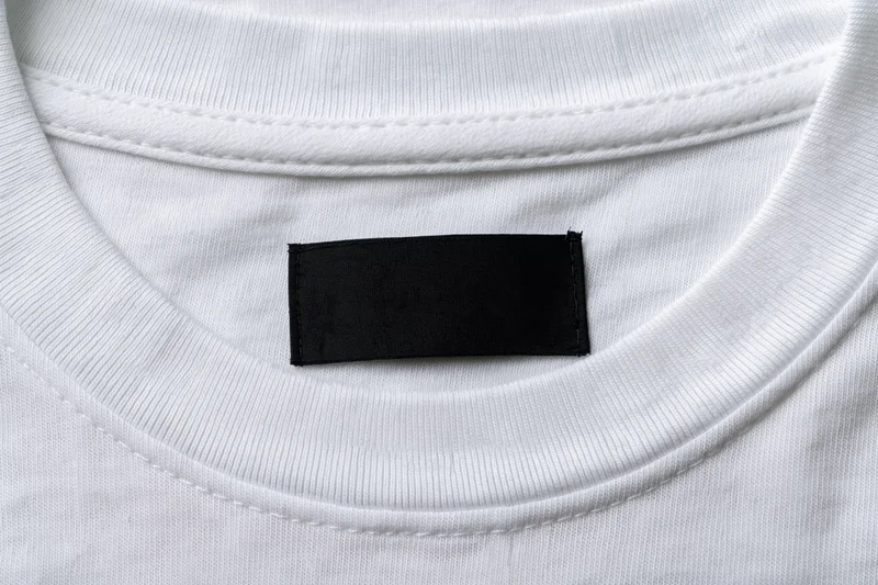 Closeup of blank black label sewn inside white tshirt collar